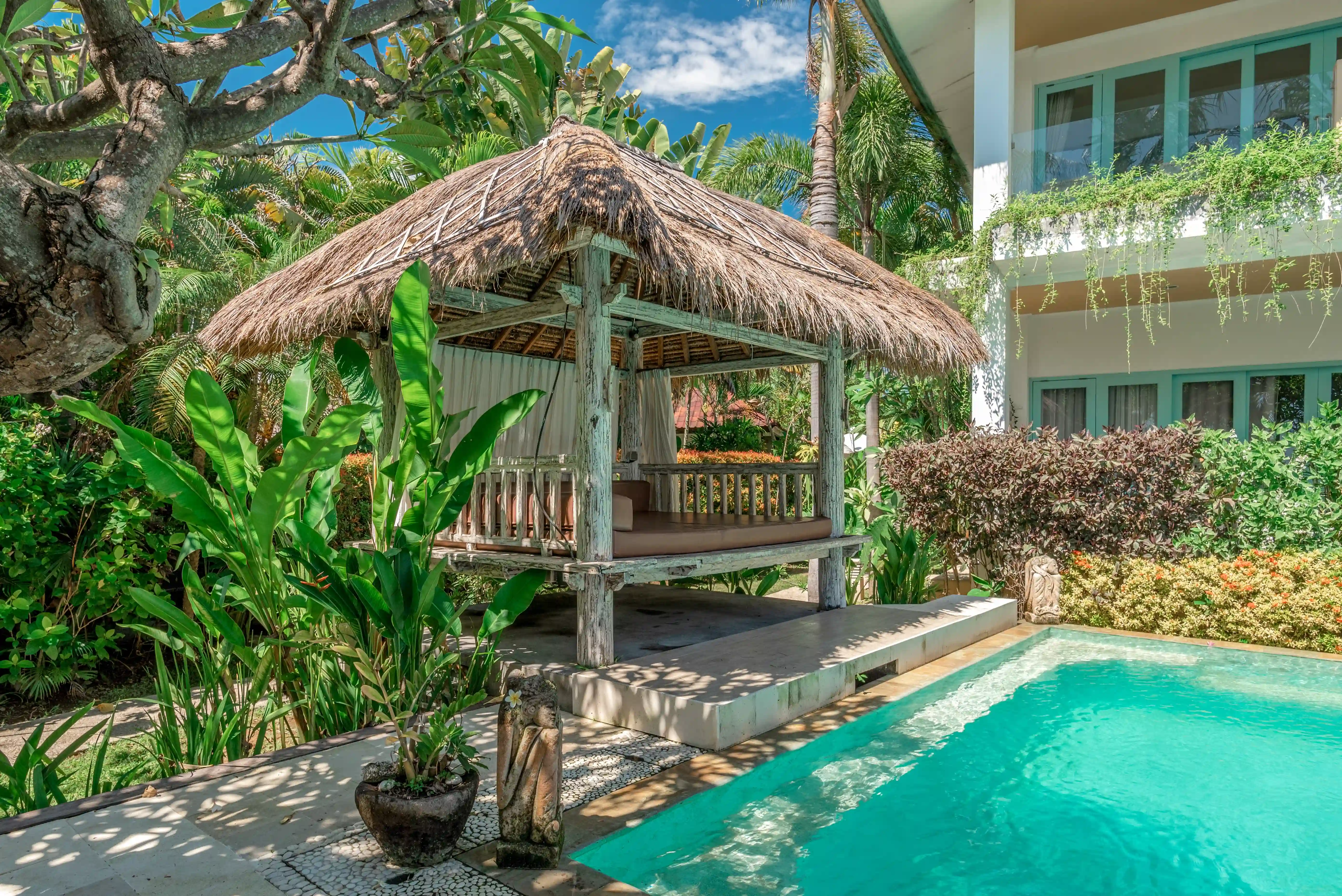 Tropical garden view with lush greenery and a stone pathway at Mayo Resort Bali