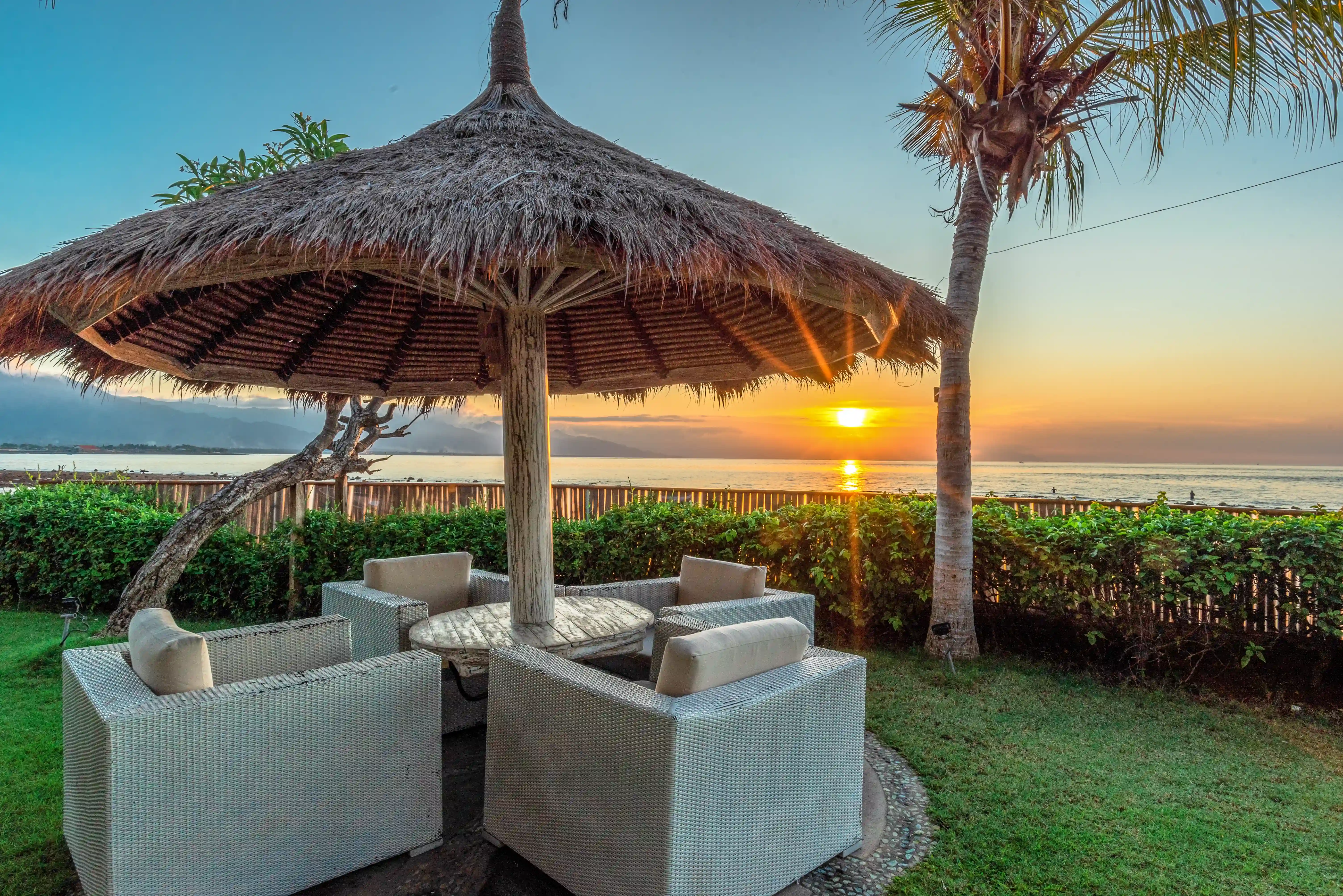 Seating area by the beach during sunset at Mayo Resort Bali