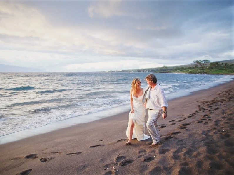 Wedding couple walking hand-in-hand along the beach at Mayo Resort