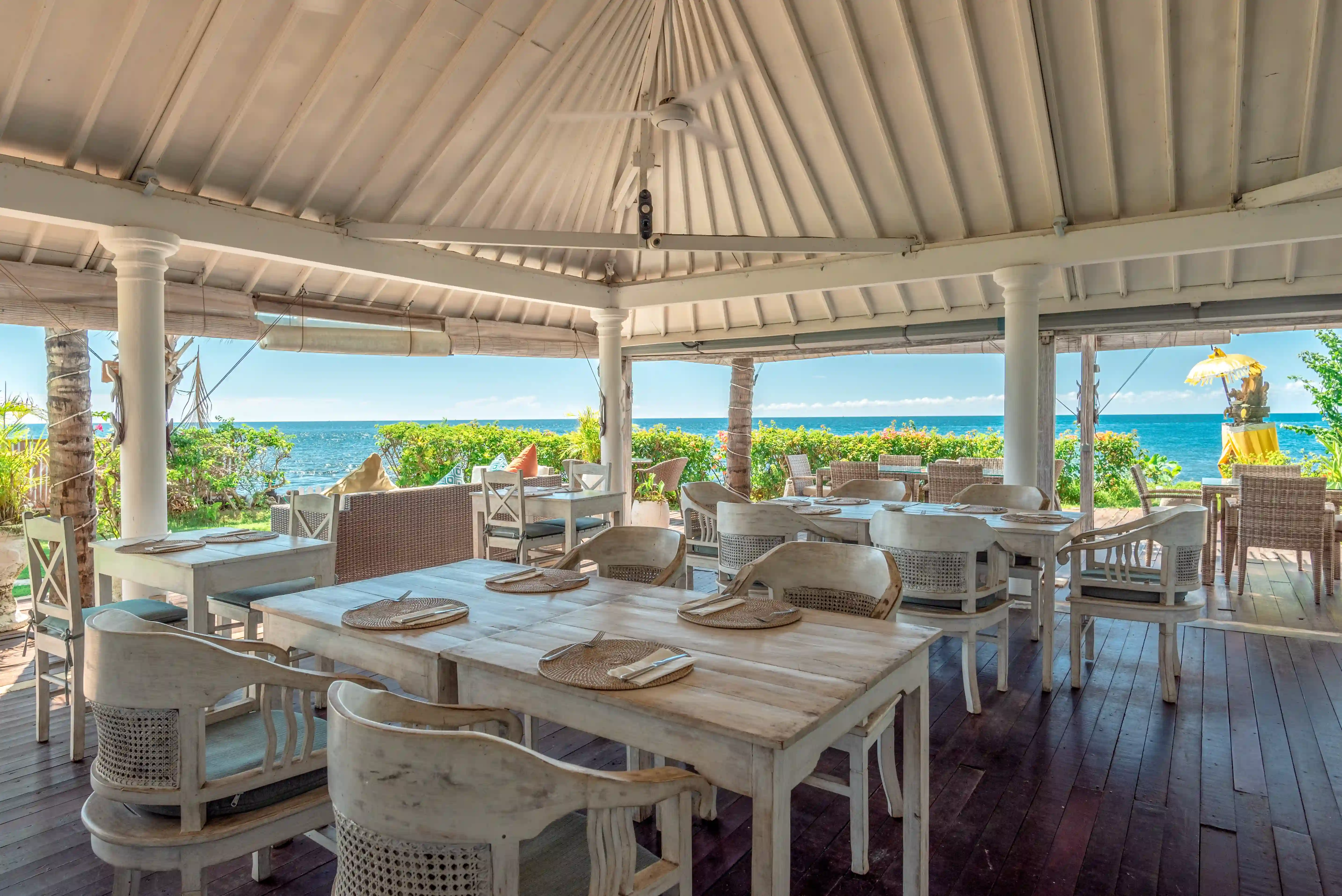 Seating area by the beach during sunset at Mayo Resort Bali