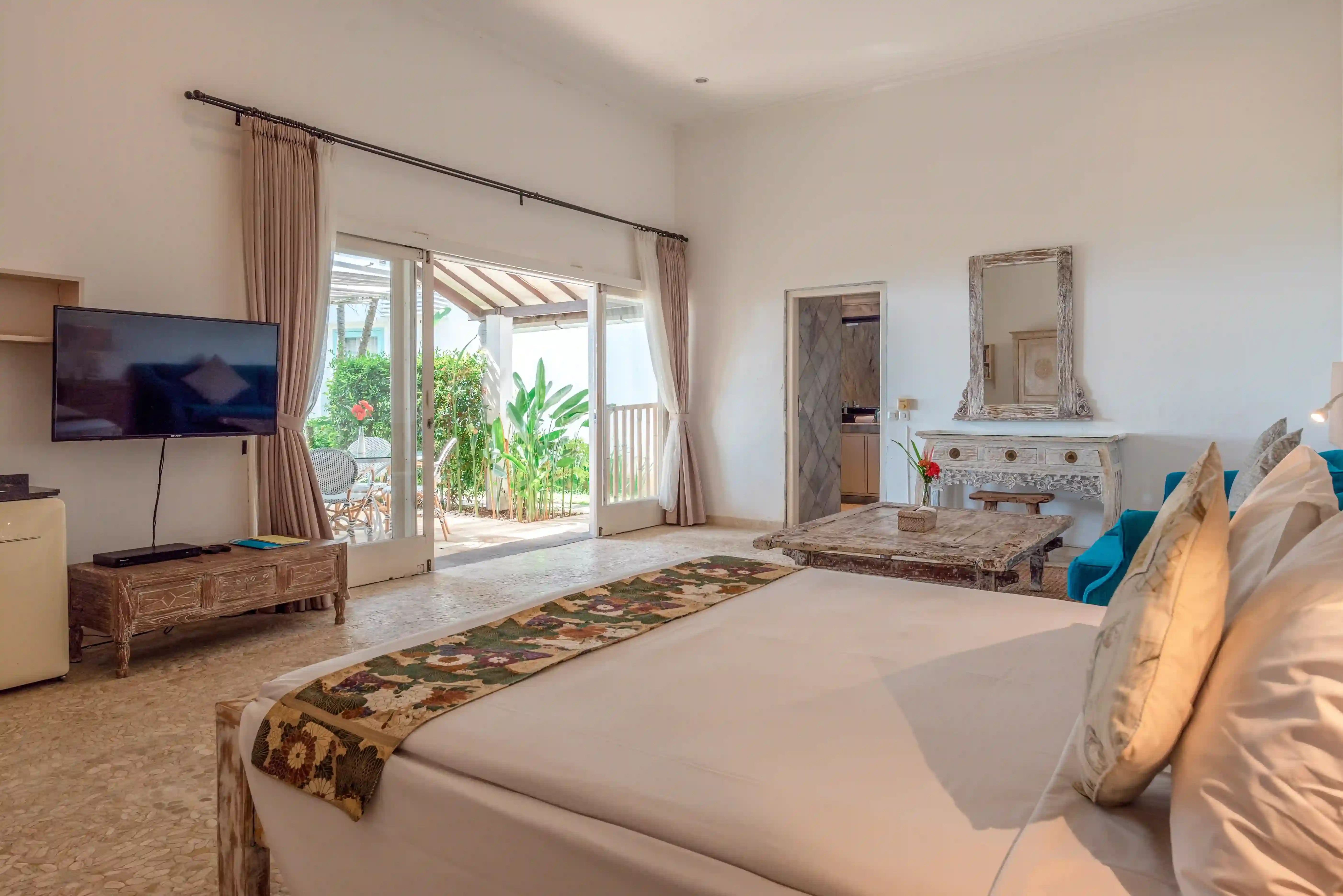 Bright garden studio bedroom with private balcony access at Mayo Resort Bali