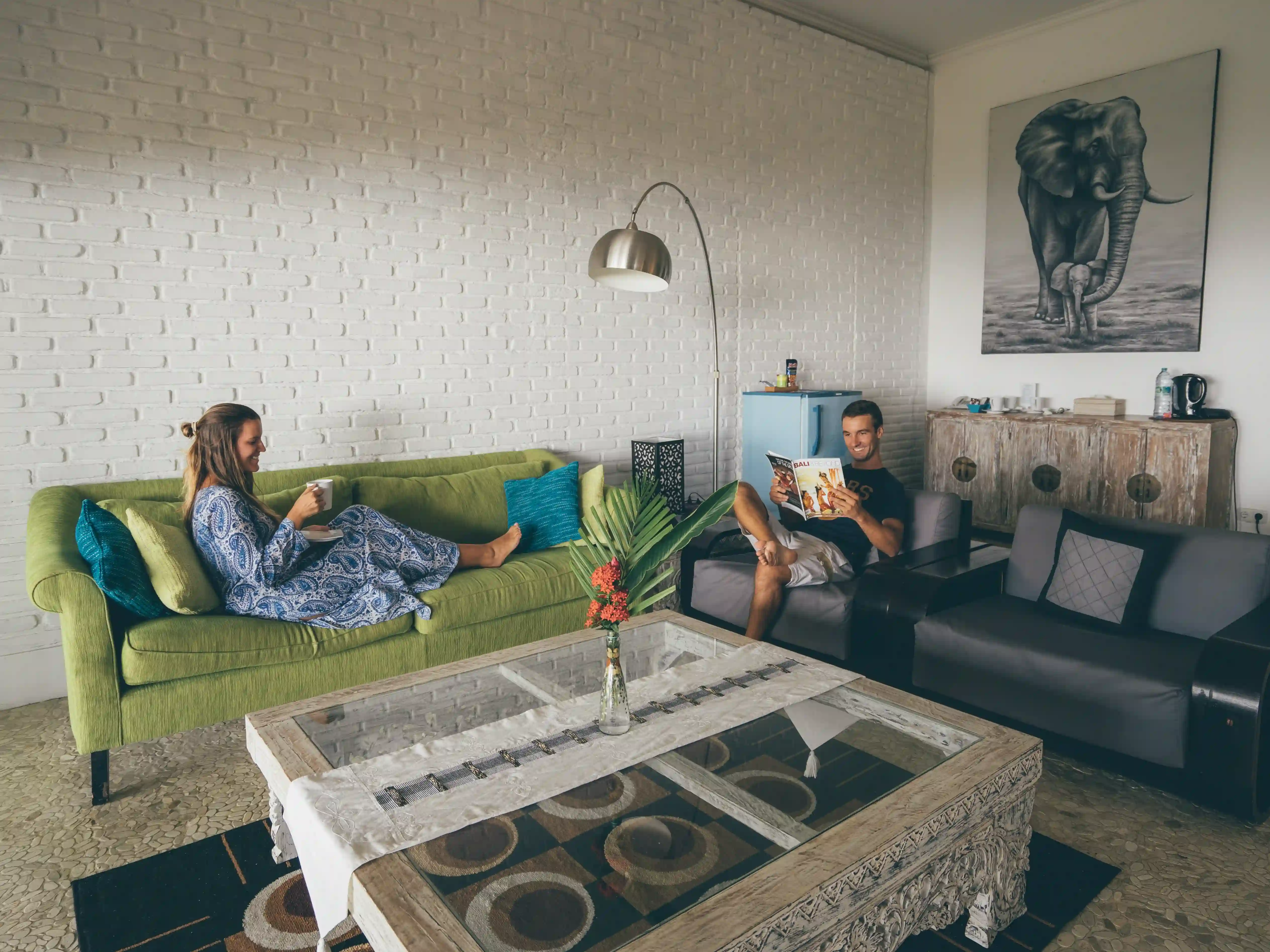Couple relaxing in the resort living room, reading and having coffee, representing a romantic or couples' getaway special offer.