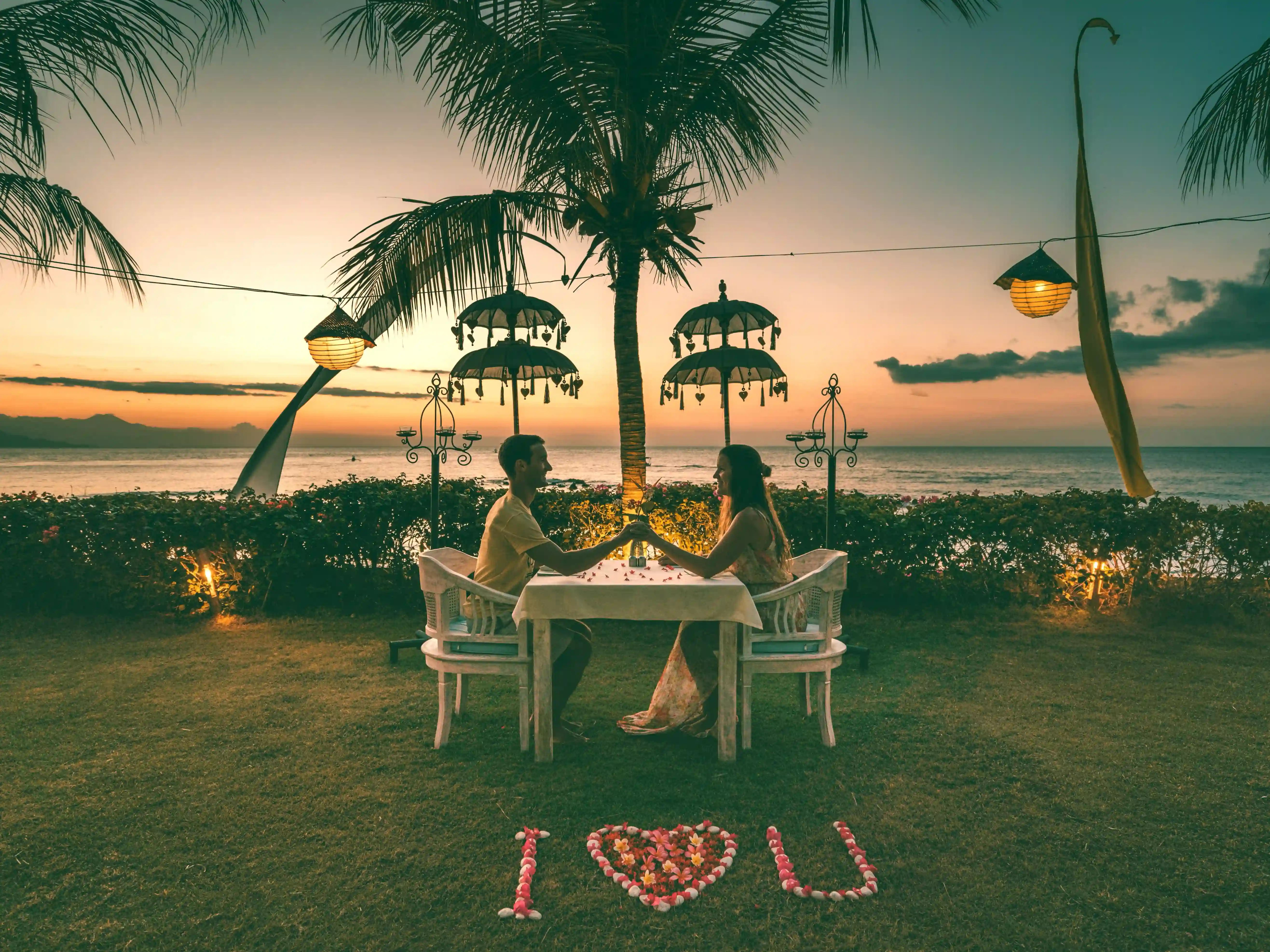 Romantic sunset private dinner for two on the lawn near the beach with 'I Love U' written in flowers